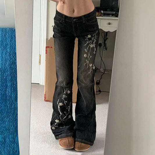 Jean Flare Vintage avec motif floral brodé, coupe ample et taille basse, style streetwear rétro et moderne, confortable et élégant.